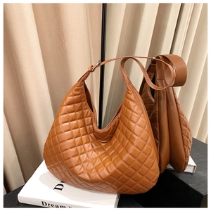 Detail of brown quilted hobo bag featuring soft faux leather texture and wide strap