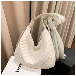 Detail view of a white quilted hobo bag featuring silver buckle and moon-shaped design