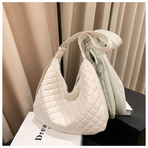 Detail of quilted rhombic pattern on off-white faux leather hobo shoulder bag