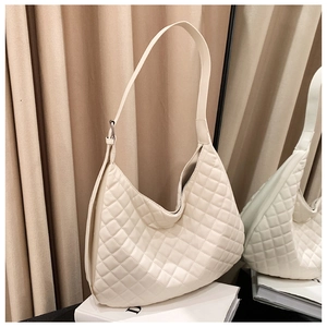 Detail of elegant cream quilted hobo shoulder bag with adjustable silver buckle strap