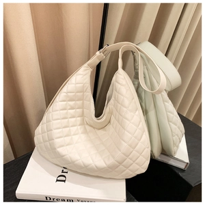 Detail of white quilted hobo bag with diamond stitching and wide shoulder strap