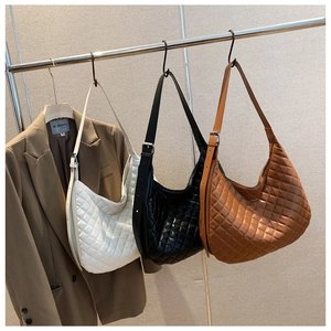 Detail of quilted hobo shoulder bags in white, black and brown with adjustable straps