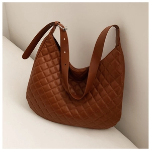 Close-up of brown quilted diamond pattern on large tote bag with silver hardware