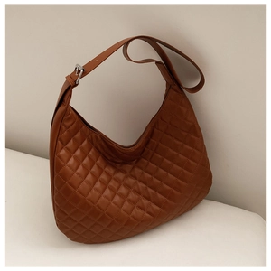 Detail of caramel brown quilted hobo bag with adjustable silver metal strap buckle