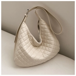 Detail of cream quilted tote bag featuring diamond stitch patterns and soft faux leather texture