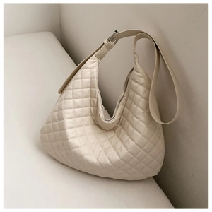 Detail of quilted rhombic pattern on off-white hobo shoulder bag with silver buckle