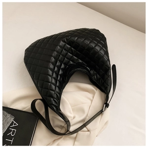 Detail of black quilted leather hobo bag with adjustable strap and silver buckles
