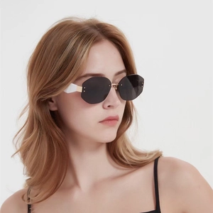 Modern rimless octagonal sunglasses with grey lenses and gold metal temples