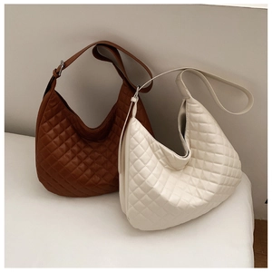 Close-up of quilted hobo shoulder bags in brown and white with glossy finish
