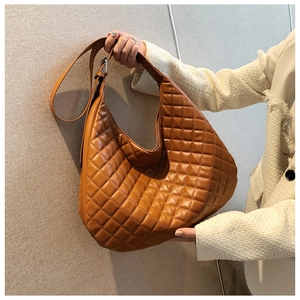 Detailed view of the brown quilted hobo bag's soft leather texture and stitching