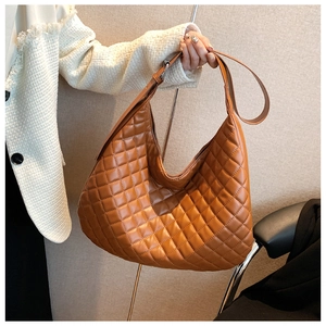 Detail of brown quilted hobo bag with adjustable strap and smooth PU leather texture