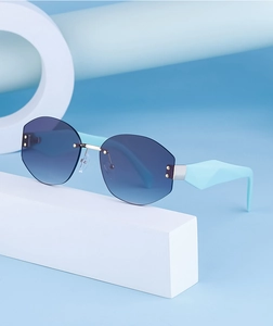 Detail view of rimless polygon sunglasses with blue gradient lenses and silver hardware