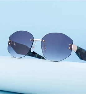 Detail of rimless polygon sunglasses with blue gradient lenses and tortoiseshell temples