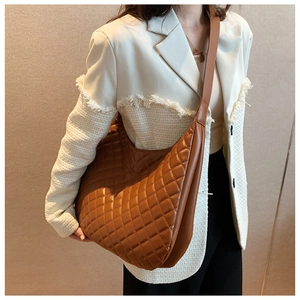 Brown quilted shoulder bag shown on model for a stylish casual look with large capacity