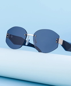 Detail of rimless geometric sunglasses with blue lenses and silver metal nose bridge