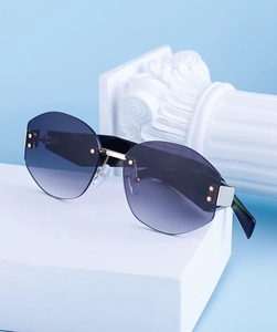 Detail of rimless polygon sunglasses with grey gradient lenses and gold metallic frame