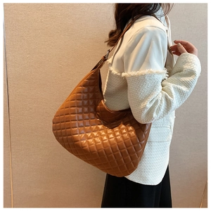 Detail of brown quilted faux leather hobo shoulder bag with adjustable strap and metal buckle