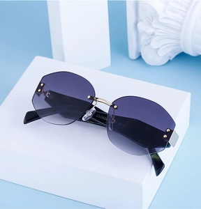 Detailed macro view of rimless sunglasses with purple gradient lenses and gold metal bridge