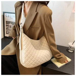 Close-up of white quilted leather hobo bag with adjustable shoulder strap for women