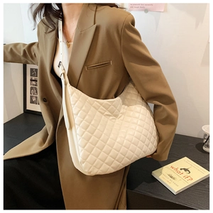 Macro shot of off-white quilted crossbody bag with stylish large rhombic patterns