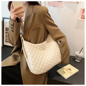 Detailed view of beige quilted leather tote bag with elegant diamond pattern stitching