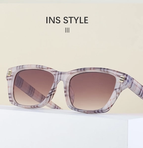 Détail de lunettes de soleil rétro à carreaux avec touches dorées et verres bruns
