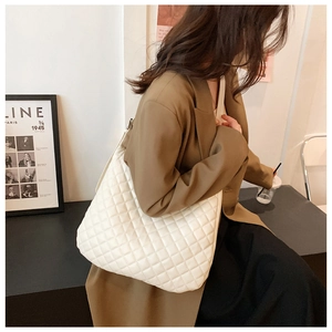 Macro shot of white quilted tote bag showing rhombus texture and large capacity for daily use