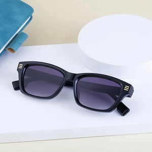 Détail de lunettes de soleil œil de chat, monture noire, verres dégradés violets et métal doré
