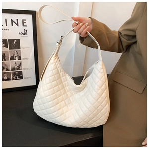 Detail of cream quilted hobo bag with adjustable shoulder strap and metal buckle