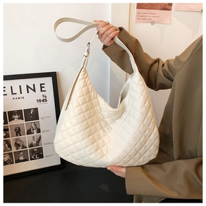 Detailed texture of beige quilted hobo bag with adjustable strap and spacious interior