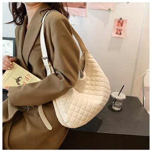 Detailed view of white quilted hobo shoulder bag with silver metallic buckle hardware