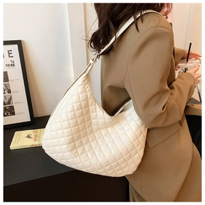 Close-up of white quilted hobo shoulder bag with classic lattice stitching pattern