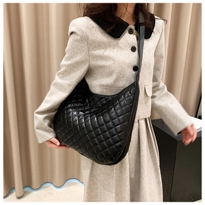 Close-up of black quilted hobo bag featuring elegant diamond stitching and a wide strap