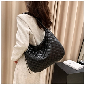 Fashionable black quilted hobo shoulder bag shown on a model with a stylish moon shape
