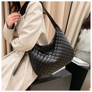 Detailed shot of black quilted large tote bag worn on shoulder for casual daily use