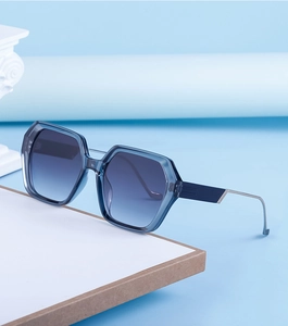 Détail de lunettes de soleil carrées bleues avec verres dégradés et branches en métal