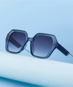 Détail de lunettes de soleil carrées bleues avec verres dégradés et charnière en métal