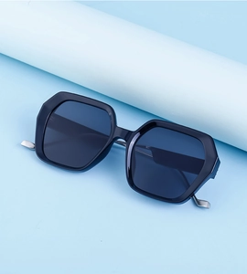 Détail de lunettes de soleil géométriques noires avec monture brillante et charnières métalliques