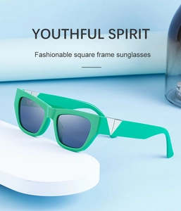 Detailed close-up of green thick square frame sunglasses with silver triangle metal accents