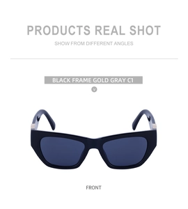 Detailed front view of black cat-eye sunglasses with gold metal hinges and gray lenses