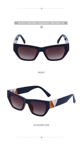 Close-up of black cat-eye sunglasses with gold V-detail and brown gradient lenses