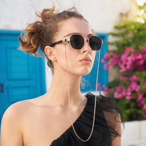 Lunettes de soleil hexagonales noires avec chaîne en métal doré pour femmes en vacances