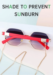 Détail de lunettes de soleil polygonales avec verres dégradés violets et chaîne dorée