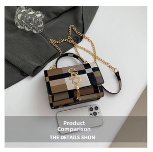 Size comparison of a plaid crossbody bag with gold logo and tassels next to a phone