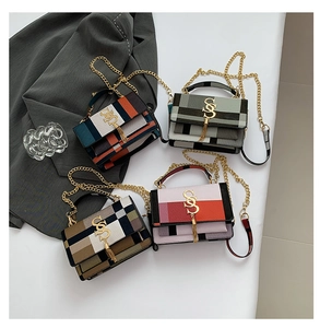 Detail of four colorful mini crossbody bags with gold chain straps and tassel logo charms