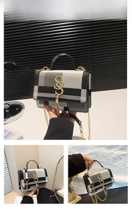 Close-up of color-block plaid crossbody bag with gold S-buckle and tassel detail