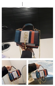 Detailed view of color-block flap bag with gold chain strap and metal logo tassel
