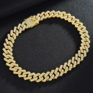 Detail view of 20mm triple-row diamond-encrusted golden Cuban link necklace on dark background