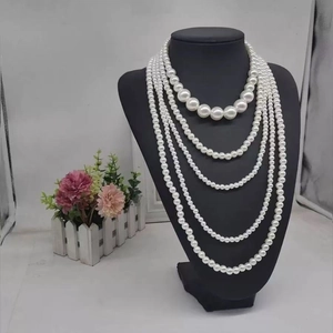 Elegant multi-layered white faux pearl necklace on a black mannequin display stand