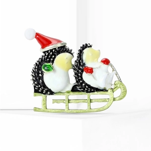 Detail of Christmas hedgehog sled brooch with red hat and enamel dripping finish